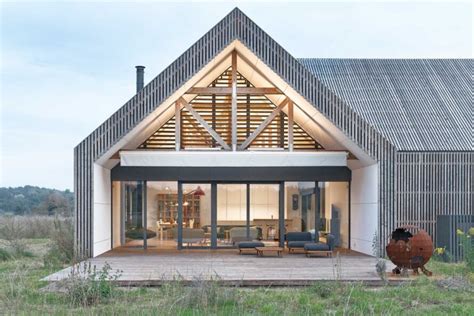 Modern barn inspired home ages gracefully in a wild Poznań meadow