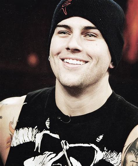 A Man With Tattoos On His Arm And Wearing A Beanie Smiles At The Camera