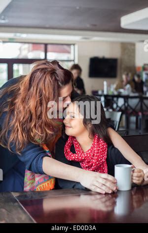 Madre e hija besándose en cafe Fotografía de stock Alamy
