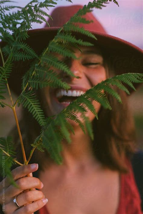 Portrait Of A Young Woman Laughing Holding A Leaf By Stocksy