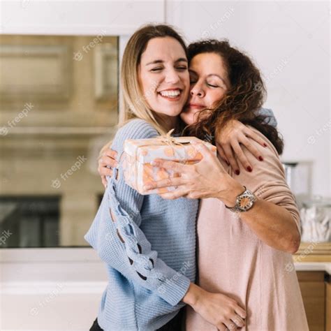 Madre E Hija Con Abrazos De Regalo En La Cocina Foto Gratis
