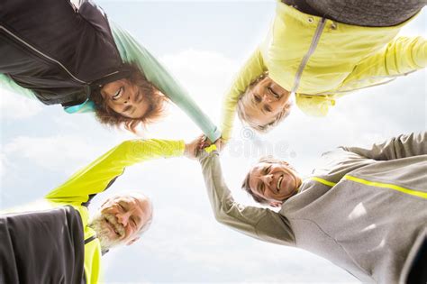 Group Of Senior Runners Outdoors Resting Holding Hands Stock Image