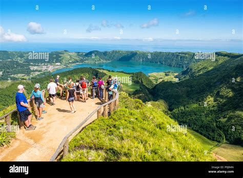 Tourists At A Viewpoint Over Sete Cidades Two Lakes And A Village In The Dormant Crater Of A