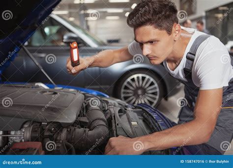 Young Handsome Car Mechanic Repairing Vehicle In His Garage Stock Photo