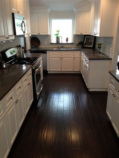 A perfect blend of dark wood. Kitchen - Dark counters, dark floors, white cabinets ...