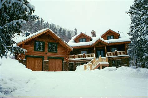 A Large Log House With Snow On The Ground