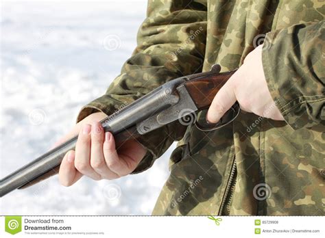 Close Up Of A Hunter Holding Old Shotgun In Winter Forest Stock Photo