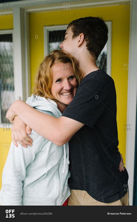 Teen Boy Giving His Mom A Hug Stock Photo OFFSET