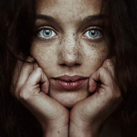 A Woman With Freckled Hair And Blue Eyes Posing For A Photo In Front Of