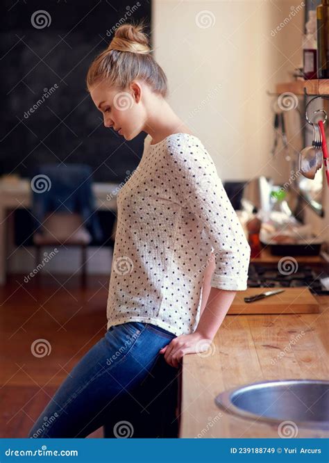 Kitchen Contemplations Shot Of A Young Woman Standing Leaning On The