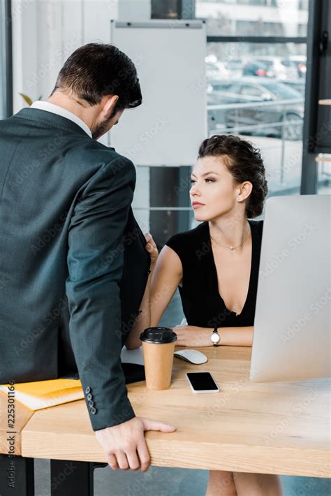 Young Seductive Businesswoman Flirting With Colleague At Workplace In
