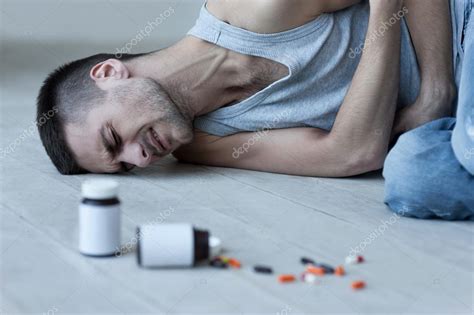 Man Lying On The Floor And Holding Hands On Stomach Stock Photo By
