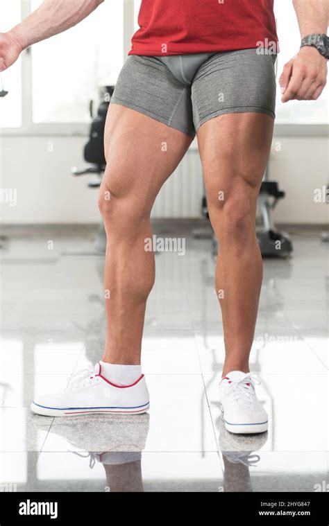 Healthy Young Man Standing Strong In The Gym And Flexing Legs Close Up