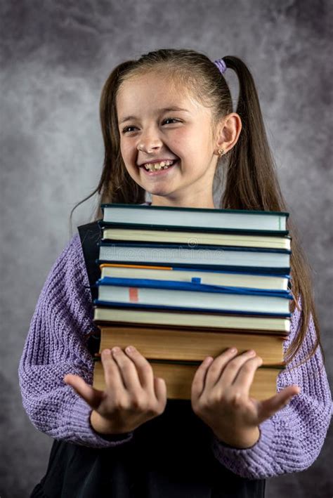 Smiling Beautiful Little Girl Holding Thick Books In Her Hands Isolated