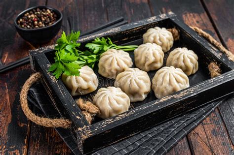 Momo Dumplings In A Wooden Tray With Herbs Dark Wooden Background