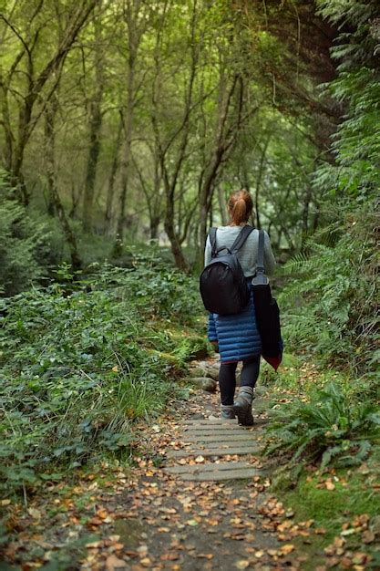 Mujer Caminando Por Un Sendero Del Bosque Foto Premium