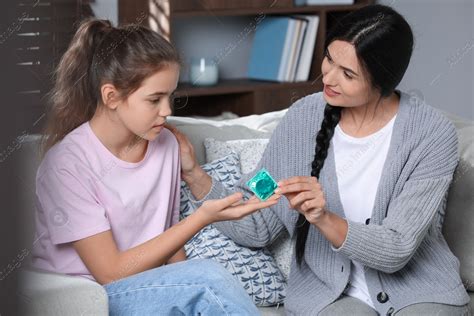 Mother Giving Condom To Her Teenage Daughter At Home Sex Education