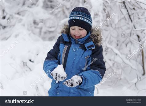 Portrait Of Cute Toddler Boy Smiling On Beautiful Winter Snowy Day