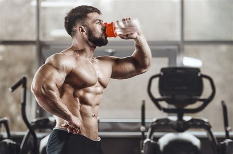 Premium Photo Athletic Men Drinking Water In The Gym