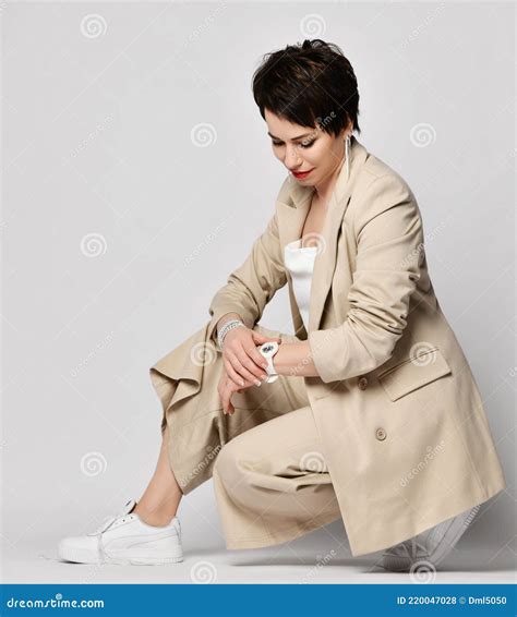 Smiling Pretty Short Haired Brunette Woman In Beige Business Smart Casual Suit And Skeakers