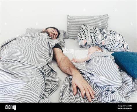 Father And Son Sleeping In Bed At Home Stock Photo Alamy