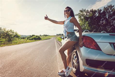 Premium Photo Beautiful Woman Hitchhiking By A Broken Car A Beautiful Young Sexy Girl In
