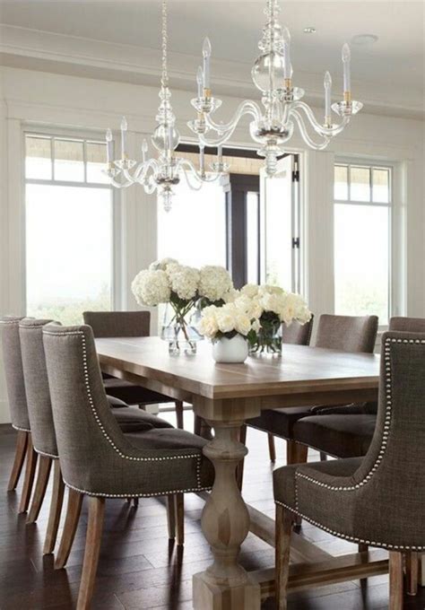 Dining room nook with with a modern chandelier, a gray china cabinent, a reclaimed wood table, and blue velvet chairs. 10 Astonishing Modern Dining Room Sets | Modern Dining Tables