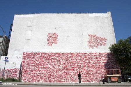 A Large White Building With Red Graffiti On It