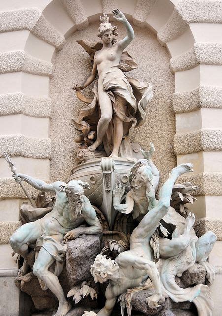 A Fountain With Statues Around It In Front Of A Building