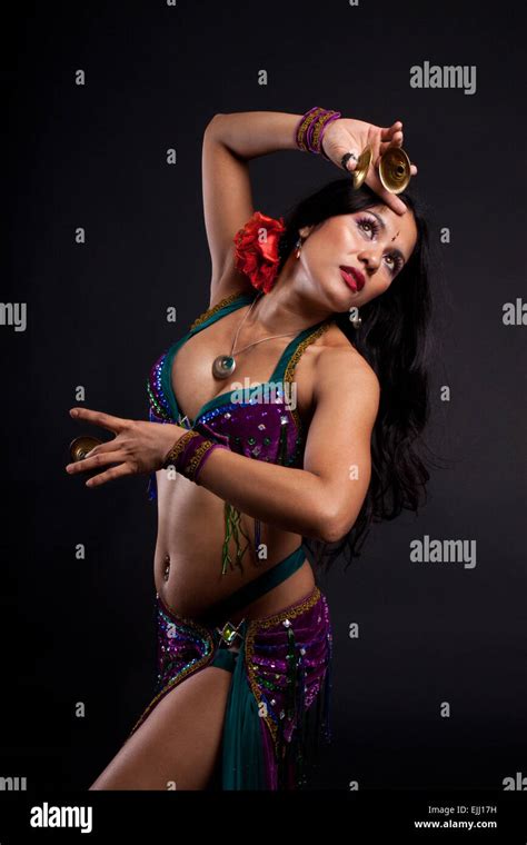 Studio Shot Of Asian Belly Dancer With Zills On Her Fingers With Black Background Stock Photo