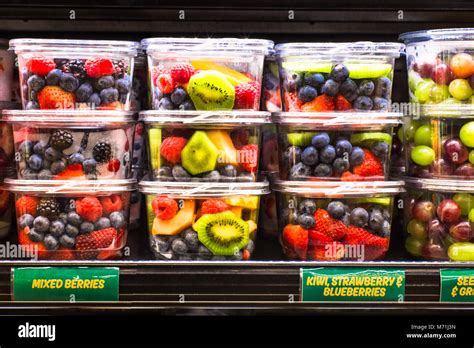Supermarket Grocery Display Case With Fresh Cut Fruit On Shelves In