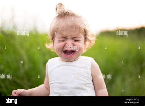 Crying Baby Alone In The Meadow Stock Photo Alamy