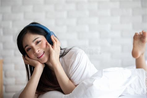 Beautiful Attractive Asian Young Woman Listen Music And Lying On Bed In
