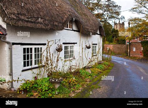Typical English Country Village Road With A Thatched Cottage And Church