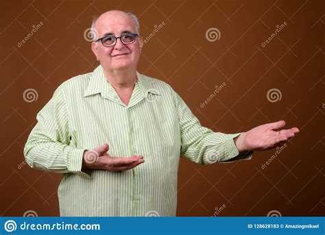 Overweight Senior Man Wearing Eyeglasses Against Brown Backgroun Stock