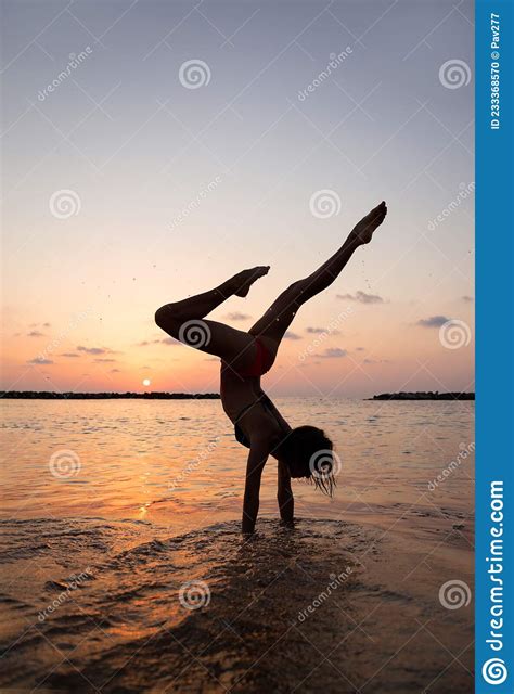 Happy Young Slender Woman Doing An Upside Down Handstand At Sunset On