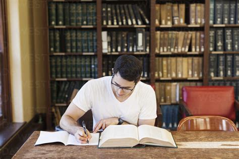 Confident Male Student Studying In Library Stock Photo