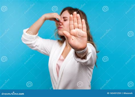 Bad Smell Portrait Of Woman Pinching Her Nose And Showing Stop Gesture