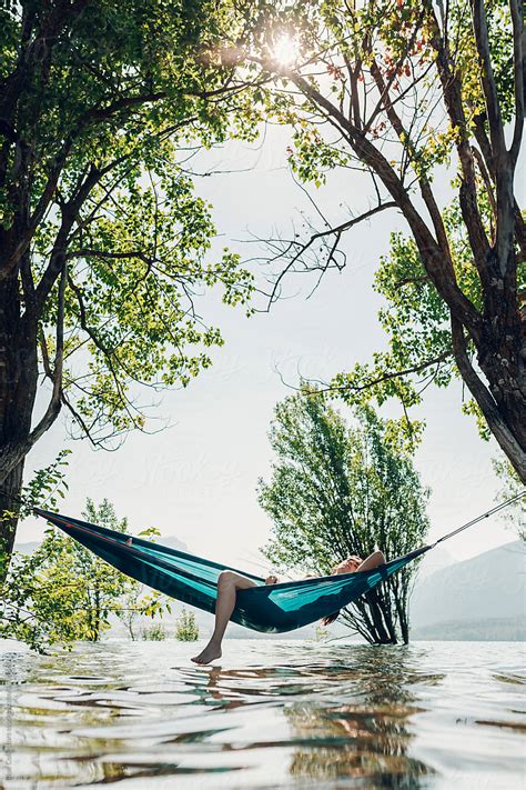 Woman In A Relaxing Time On A Hammock Over The Lake By Stocksy