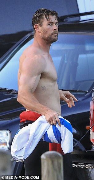 byron babe chris hemsworth flaunts his bulging muscles as he strips off his wetsuit after