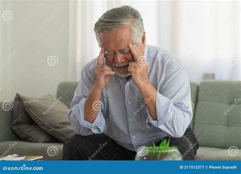 Asian Elderly Man With A Headache Sitting On A Bed In Morning Stock