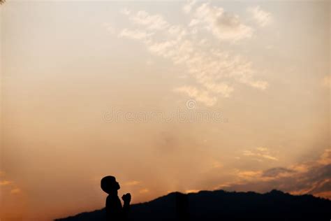 Silhouette Of A Man Prayer On Mountain At Sunset Concept Of Religion