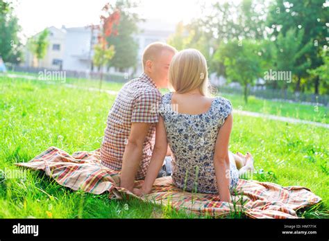 Young Couple Man And Woman Sitting On A Bench Hugging In Park Ribbon
