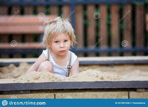 Cute Toddler Child Blond Boy Playing In The Sandpit In The Park Stock