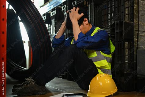 Depressed Male Worker Leaning Against Rack Feeling Tried After Overwork