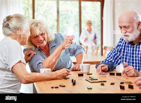 Grupo De Ancianos En La Mesa Jugando Domino Como Una Terapia De Juego O