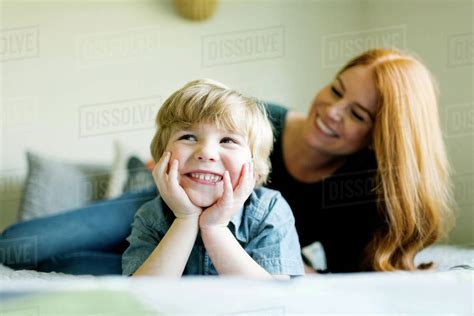 Smiling Mother And Son Lying On Bed Stock Photo Dissolve