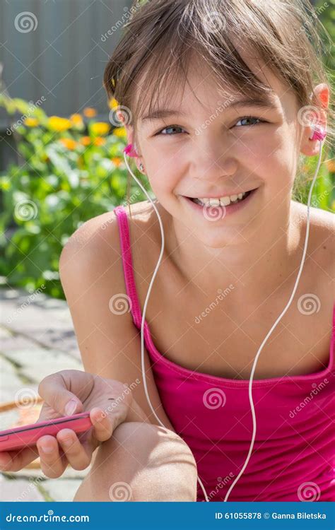 Милая маленькая девочка в наушниках слушая к музыке Стоковое Фото изображение насчитывающей