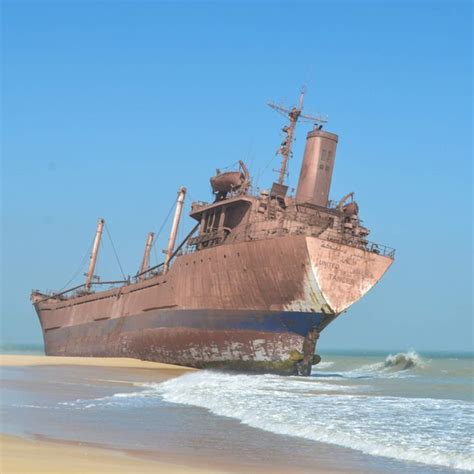 An Old Rusted Ship Sitting On The Beach