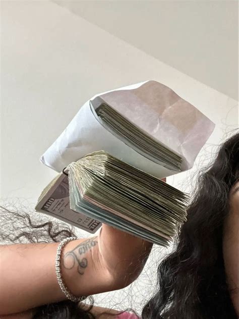 A Woman Is Holding Stacks Of Money In Front Of Her Face